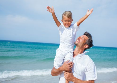 Father and son having fun on tropical beach