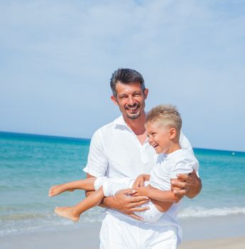 Father and son having fun on tropical beach