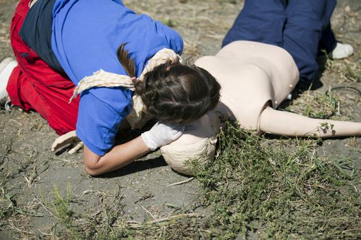 CPR practitioner examining airways on dummy