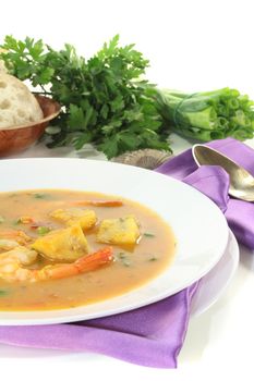 delicious bouillabaisse with seafood and parsley on a light background