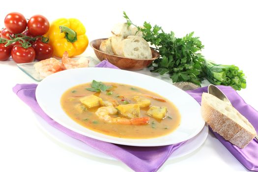fresh healthy bouillabaisse with seafood and parsley on a light background