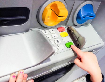 Minor at ATM machine, pressing the green OK button