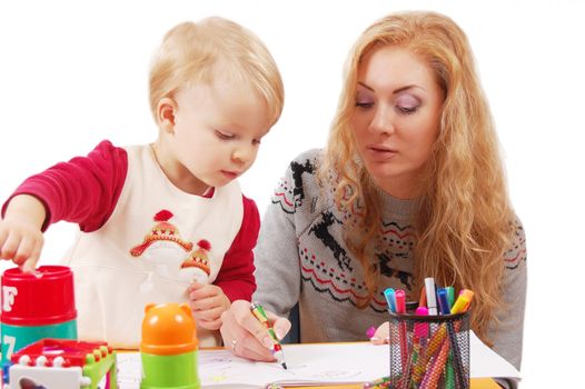 Little daughter learning to draw with her mother over white