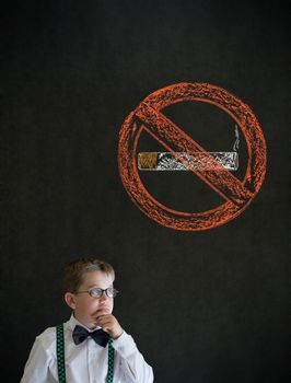 Thinking boy dressed up as business man with no smoking chalk sign on blackboard background