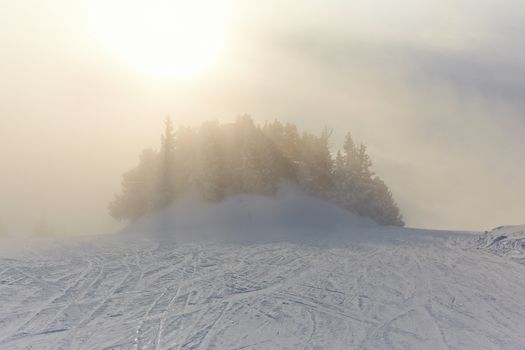 Foggy winter landscape with skiing slope