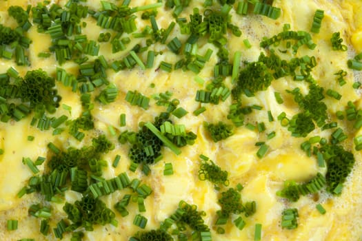 Omelet scrambled eggs with chives and herbs in a close up view