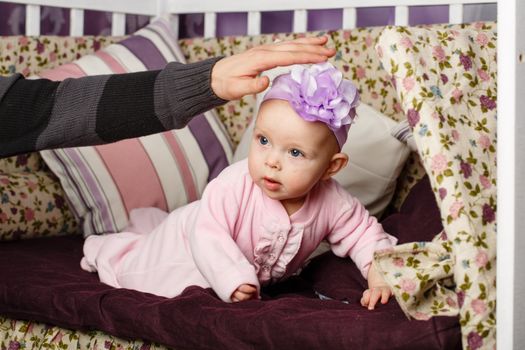 Little girl sitting on couch, and father stretches out his hand