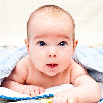 Little baby girl lying under towel