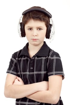 Portrait of young boy listening to music on headphones against white background 