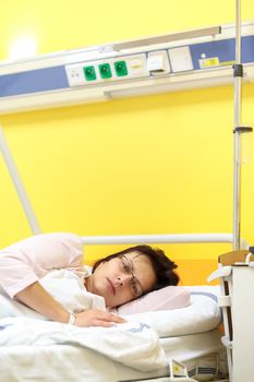 Real people in real situation, sad middle-aged woman lying in hospital with pneumonia