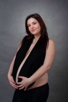 beautiful smiling pregnant young woman tenderly holding her tummy