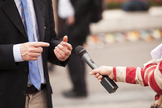 A journalist is making a interview with a microphone