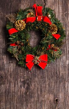 Christmas wreath with decorations on the rustic wooden background