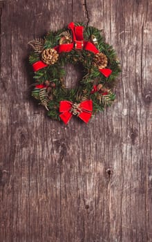 Christmas wreath with decorations on the rustic wooden background