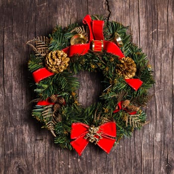 Christmas wreath with decorations on the rustic wooden background