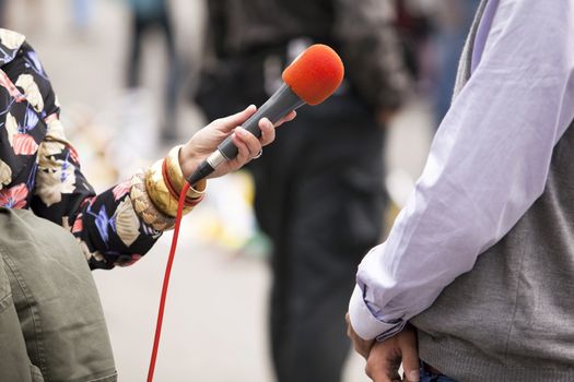 A journalist is making a interview with a microphone