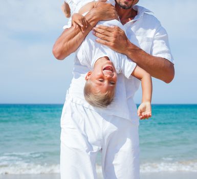 Father and son having fun on tropical beach