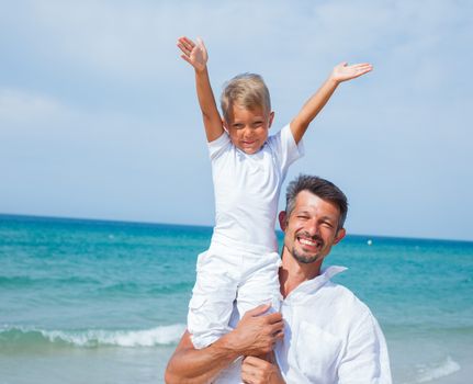 Father and son having fun on tropical beach