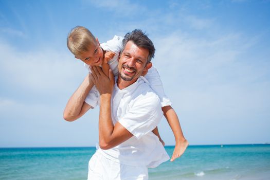 Father and son having fun on tropical beach