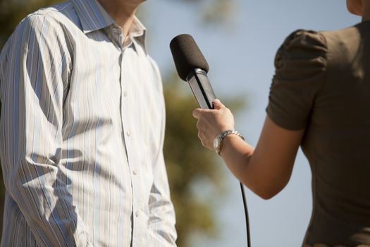 A journalist is making a interview with a microphone