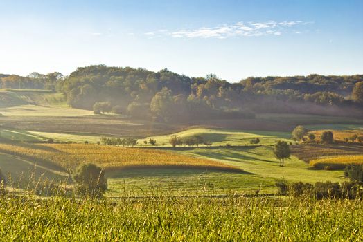 Early morning landscape in fog, idyllic fields and hills