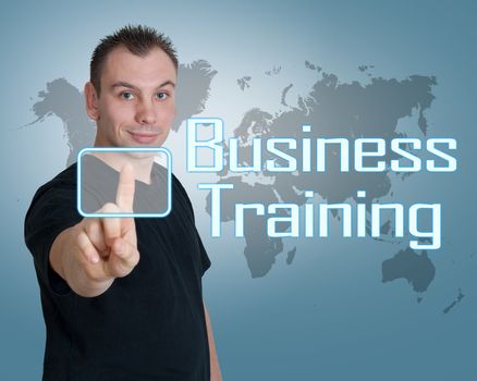 Young man press digital Business Training button on interface in front of him