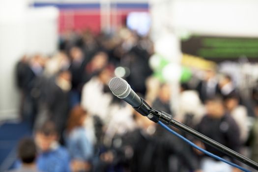 Microphone in focus against blurred audience