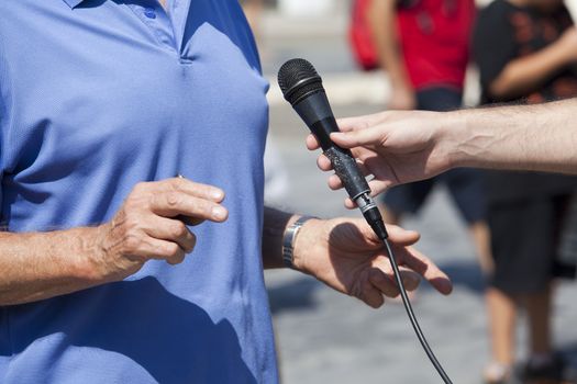 A journalist is making a interview with a microphone