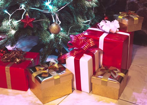 Presents boxes under the Christmas tree. Gold, red and white colours