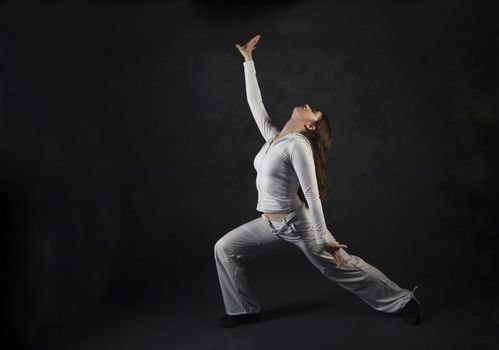 Young woman posing against gray concrete wall