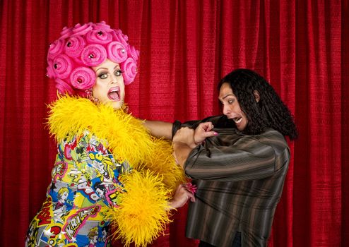 Excited drag queen in boa pulling on a man