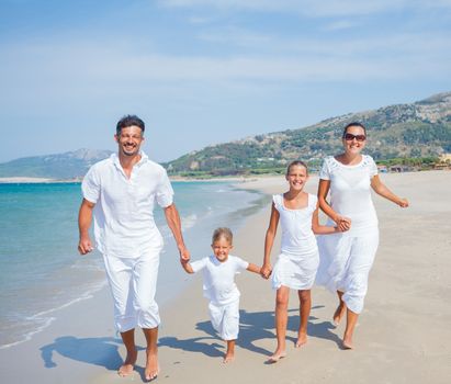 Photo of happy family running on the beach