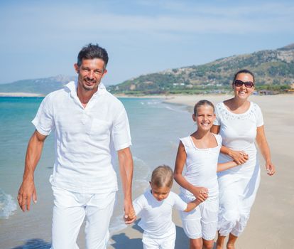 Photo of happy family running on the beach