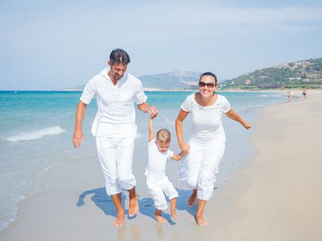 Photo of happy family running on the beach