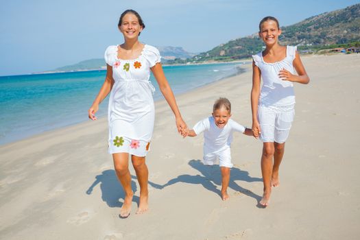 Adorable happy boy and girls running on beach vacation