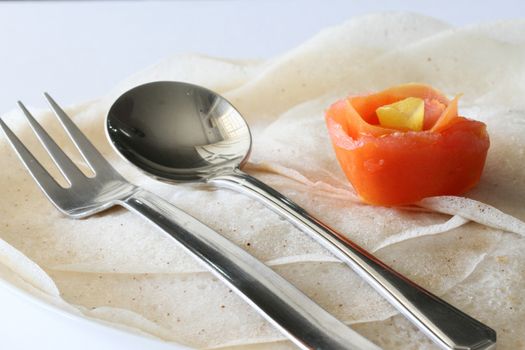 Isolated view of Indian traditional breakfast Thosai with spoon and fork with tomato flower