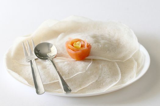 Isolated view of Indian traditional breakfast Thosai with spoon and fork with tomato flower