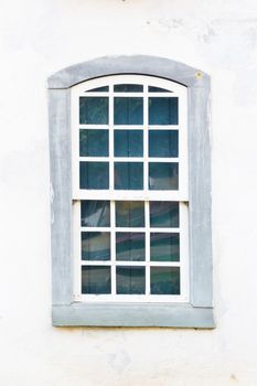 Decorative, colonial, grey, vintage, window on a white wall in Paraty (or Parati), Brazil.