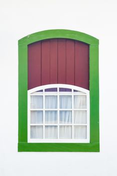 Decorative, colonial, green, vintage, window on a white wall in Paraty (or Parati), Brazil.