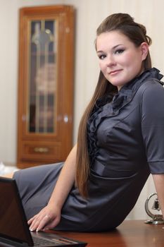 Girl sitting on the desk in the office