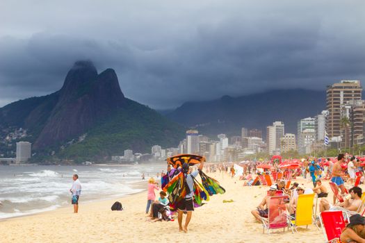 RIO DE JANEIRO - NOVEMBER 03 2012: Tourist and local people peacefully enjoying on a lively Ipanema beach before the opcoming tropical storm on November  03, 2012 on Copacabana, Rio de Janeiro, Brazil.