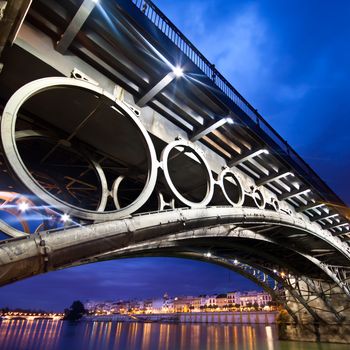 Panorama of Seville riverside at down under the Triana Bridge, the oldest bridge of Seville.