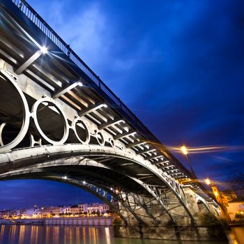 Panorama of Seville riverside at down under the Triana Bridge, the oldest bridge of Seville.