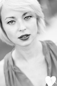 Black and white portrait of a self-confident woman shot outside in the garden.