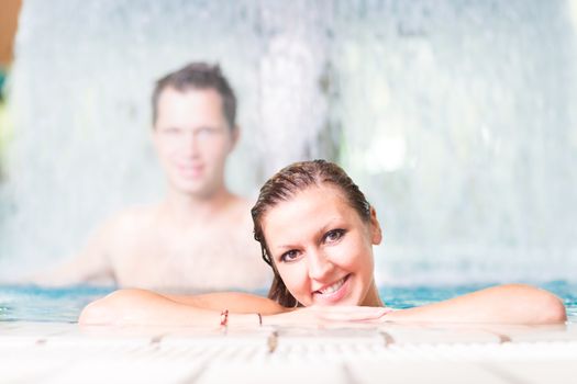 Young couple relaxing in the indoor swimming pool.