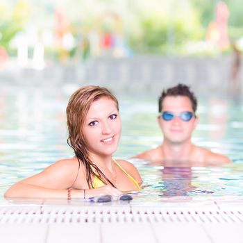 Young couple relaxing in the indoor swimming pool.