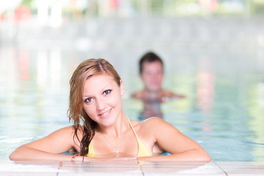 Young woman relaxing in the indoor swimming pool.