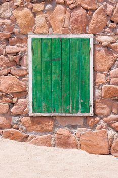 Aged grunge weathered green window shutter. Can be used as a Mediterranean background.