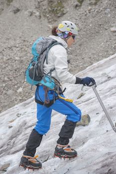 Girl climb up on the ice at glacier