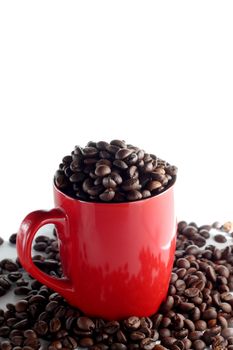 Red cup full of roasted brown coffee beans